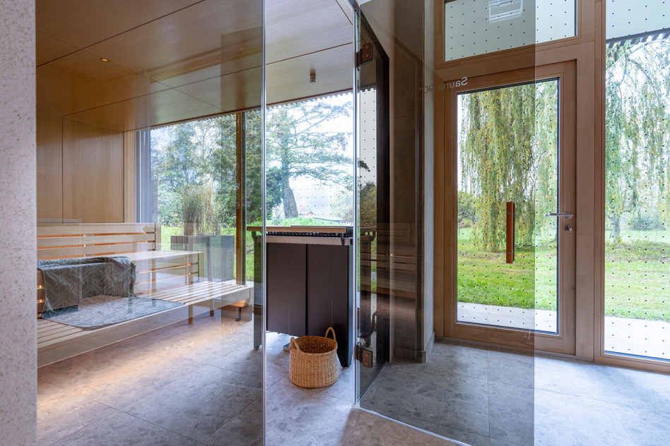 Finnische Sauna im Seegut Zeppelin mit Holzbänken, warmer Beleuchtung, Handtuch, Holzkübel und Kelle