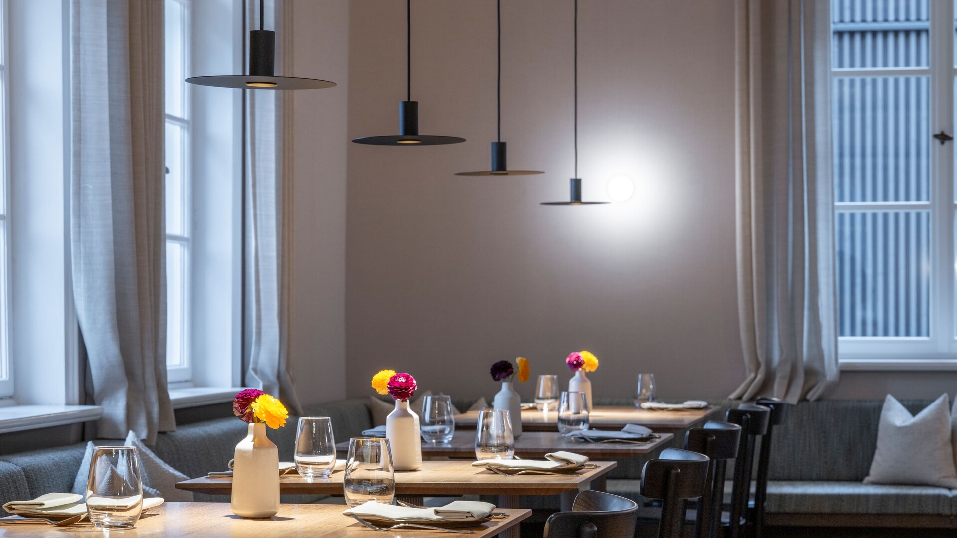 Restaurant Pinus im Seegut Zeppelin mit gedeckten Tischen, herbstlicher Blumendeko und hohen Fenstern