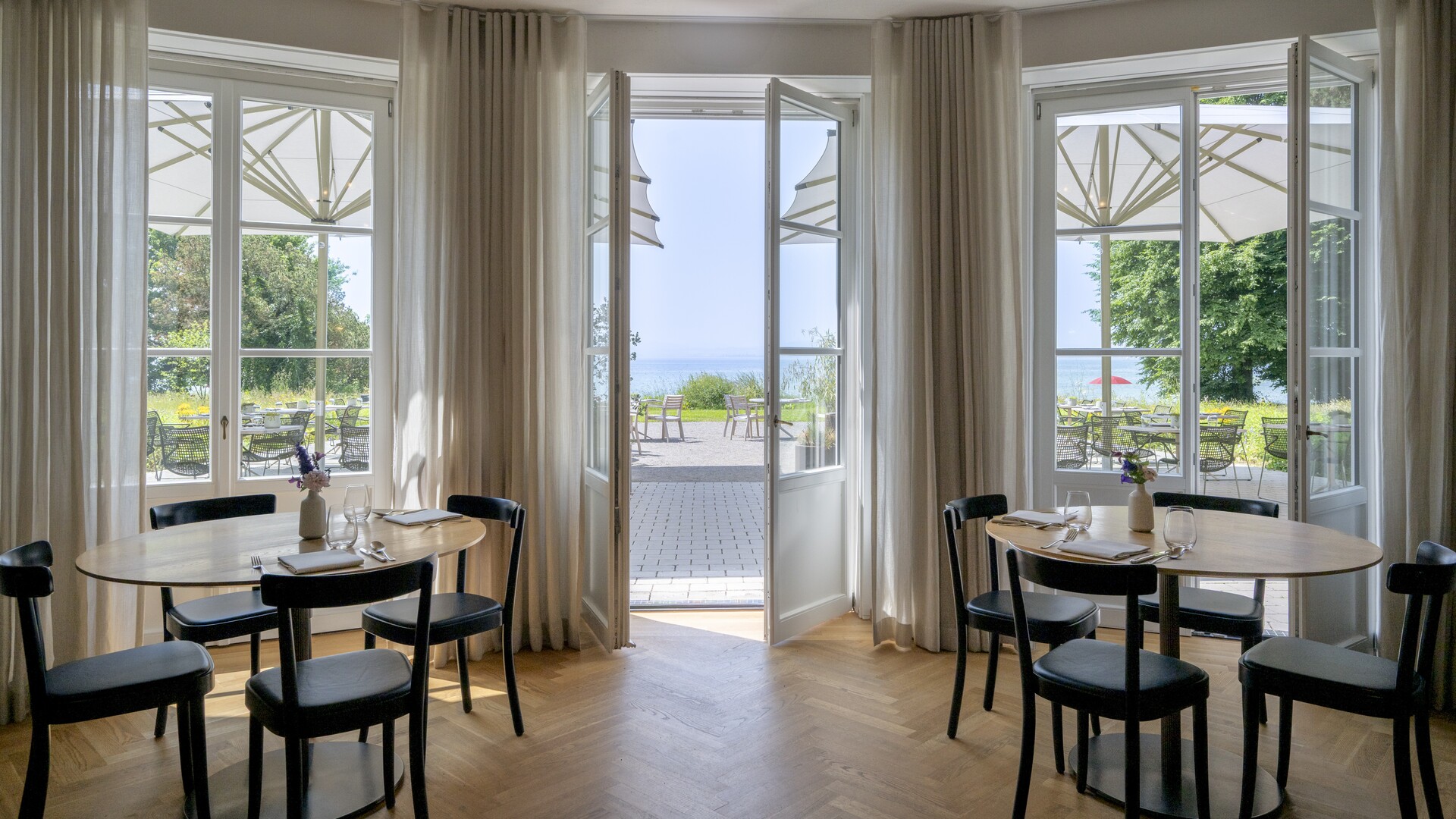 Restaurant Pinus im Seegut Zeppelin mit gedeckten Tischen und Flügeltüren zur Terrasse mit Seeblick