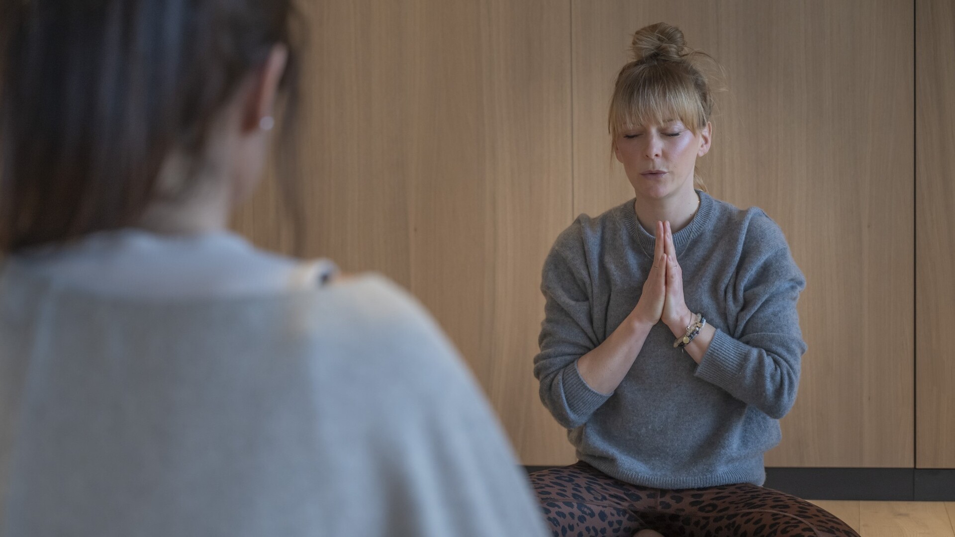 Yogalehrerin Birte Mittelmeier meditiert mit gefalteten Händen im hellen Yogaraum des Seegut Zeppelin am Bodensee