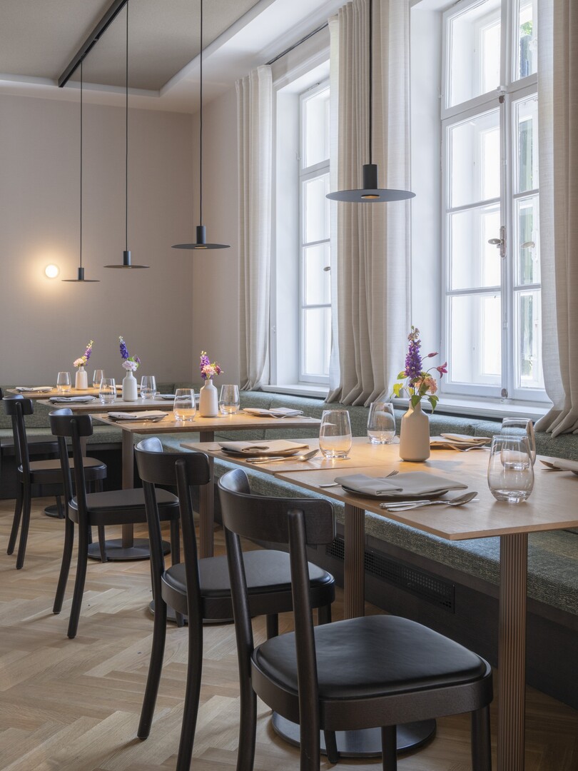 Restaurant Pinus in der denkmalgeschützten Villa Gminder mit gedeckten Tischen, hohen Fenstern und Pendelleuchten