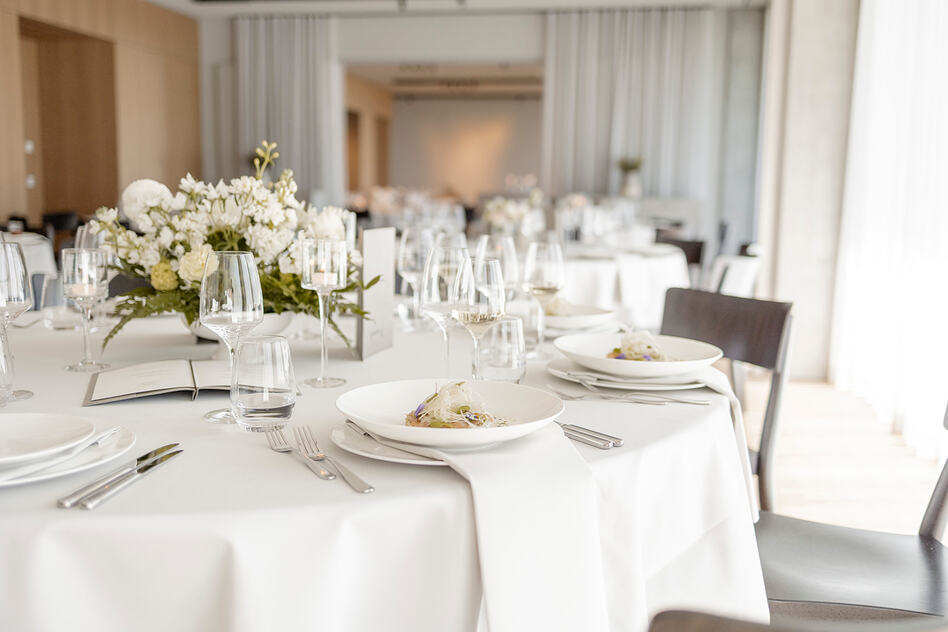 Festlich eingedeckte Hochzeitstafel im Seegut Zeppelin mit weißer Tischwäsche und weißen Blumengestecken