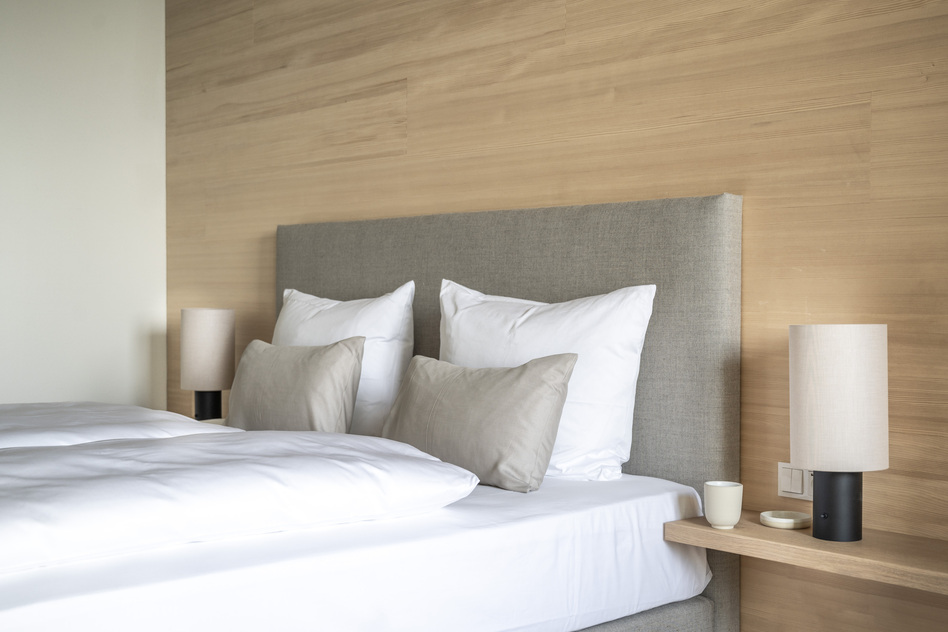 Bed with reading lamp in the Waldzimmer Terrasse at Seegut Zeppelin
