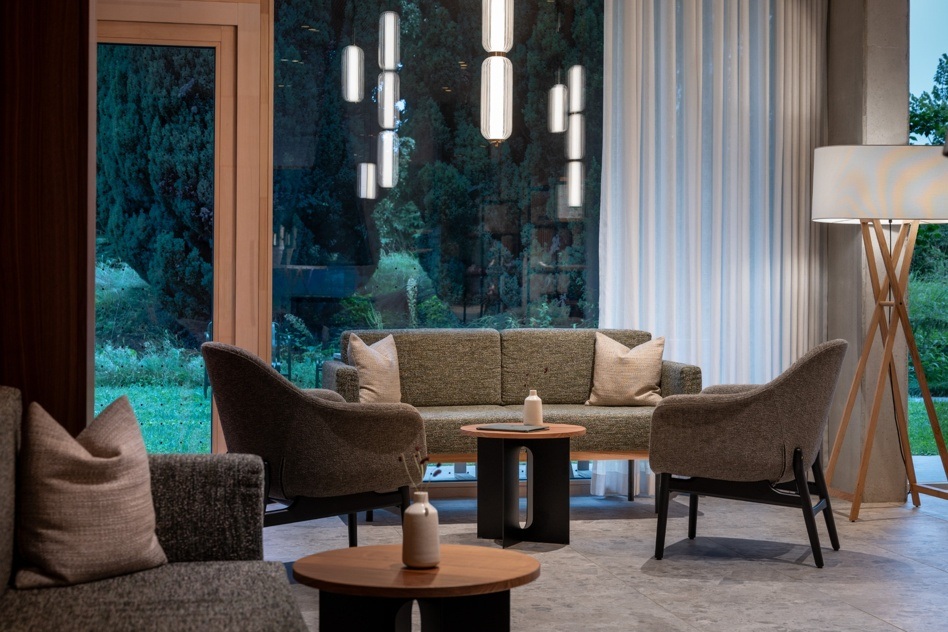 Modern hotel lounge at Seegut Zeppelin with armchairs, sofa, pendant lights and floor-to-ceiling windows